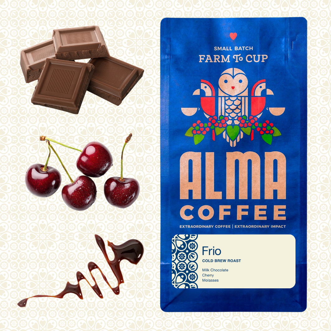 Alma Coffee Frio Cold Brew Roast bag shown on a patterned cream background, with chocolate pieces, cherries, and chocolate drizzle arranged around it as flavor cues. The bag is blue with a stylized owl and the text 'ALMA COFFEE' and 'Frio'.