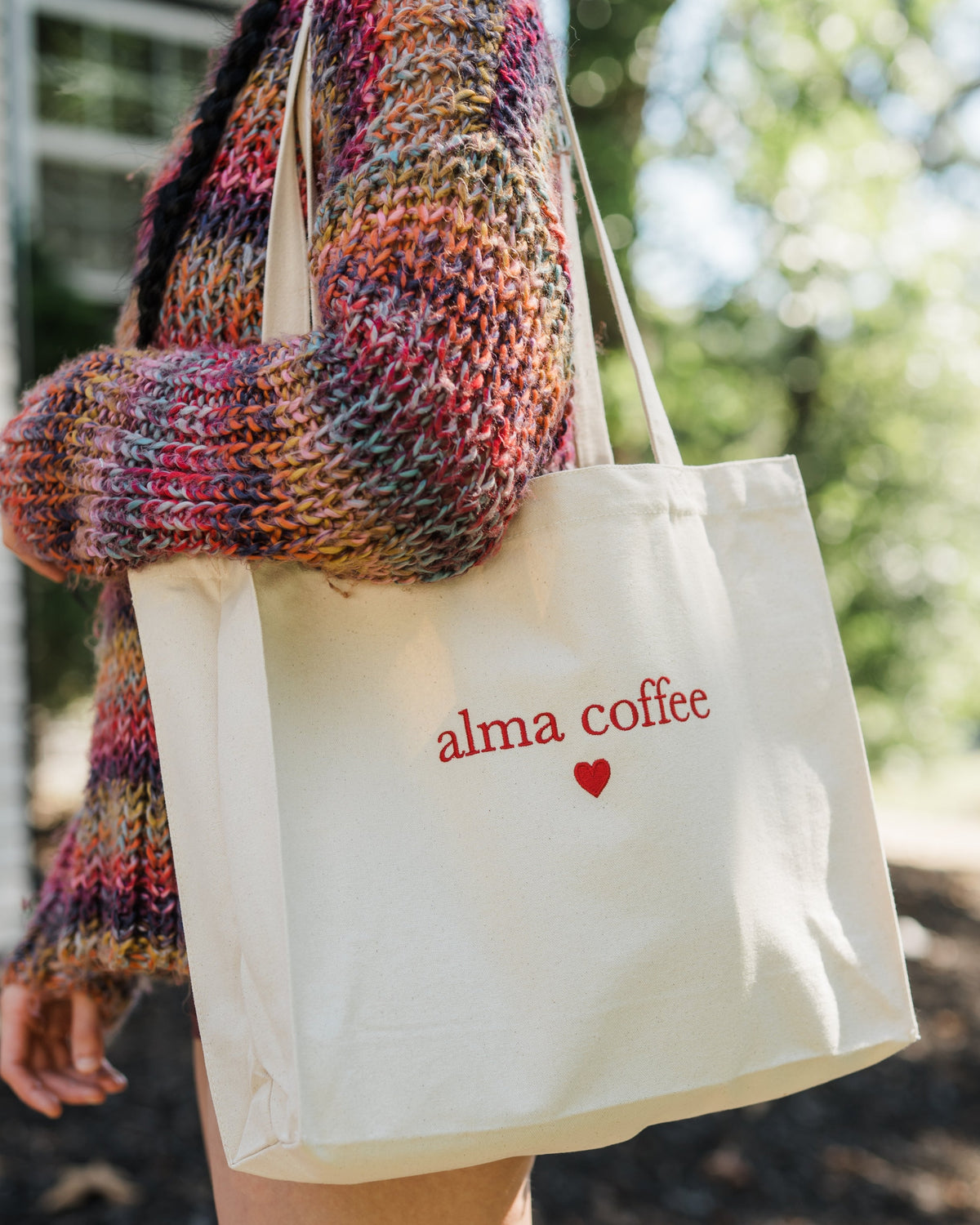 blue alma coffee reusable cup and black alma coffee reusable cup in a cheers position